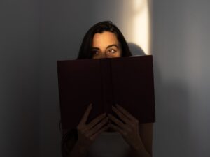 woman covering her face with a book